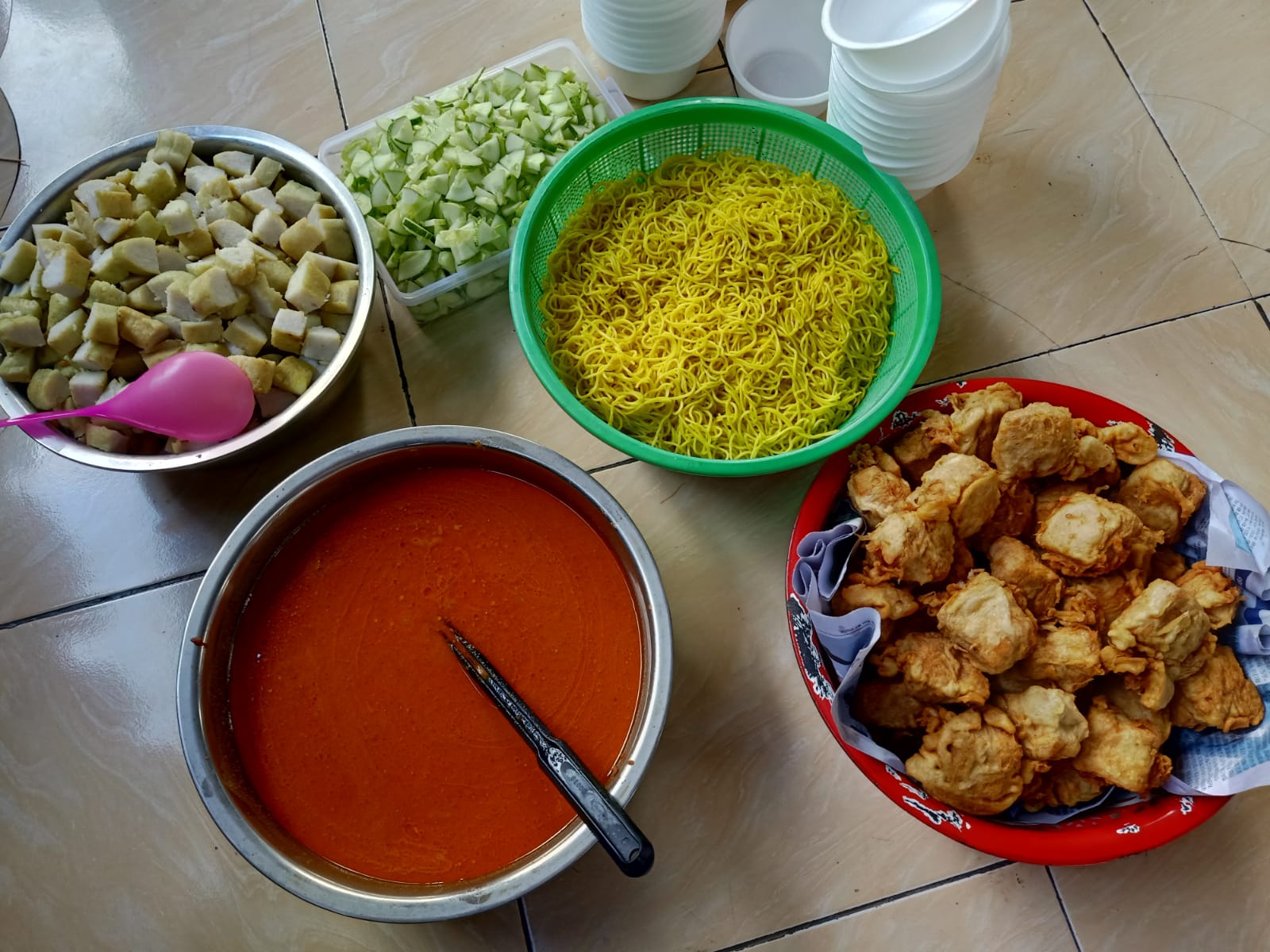 Sajian lezat berupa kuah rempah, tahu, mi kuning, dan potongan ketupat